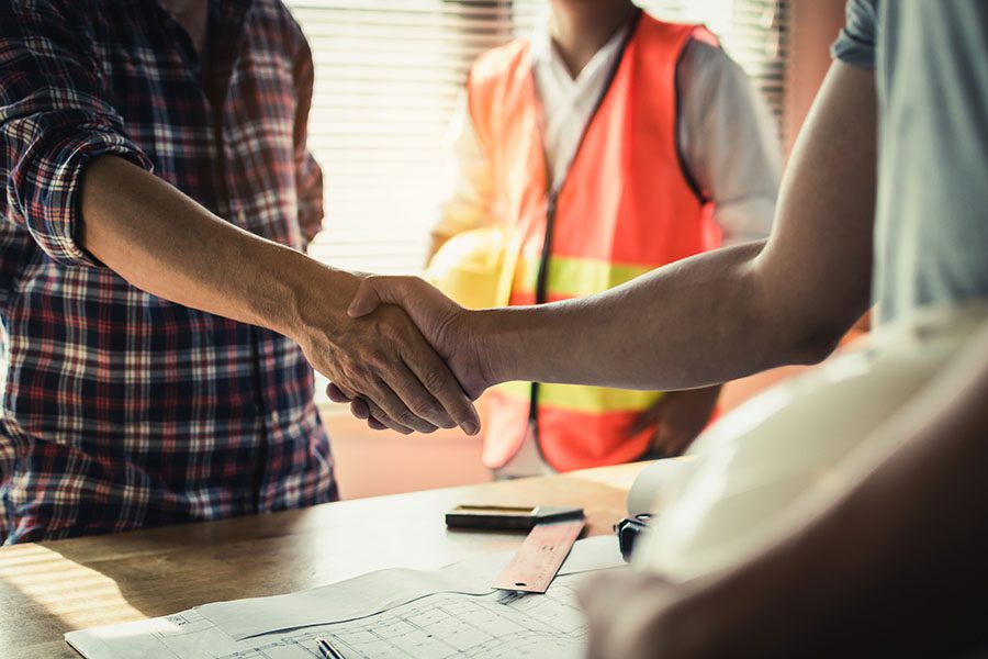Specialized Business Insurance Contractor Shaking Hands With Clients In Office